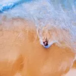 Uomo in Spiaggia bagnato dal Mare